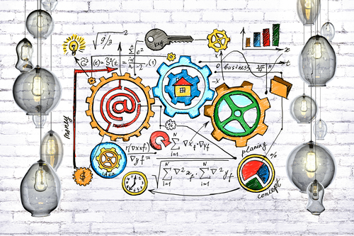Colorful gears and charts on a white brick wall illustrating process, planning, and technology innovation.